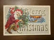1915 Embossed Merry Christmas Postcard-Santa Cutting Tree Down in Snow picture