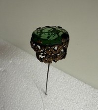 antique hat pin with large green cut glass and lots of filigree picture