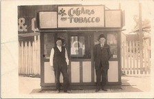 Two Men Posing in Front of Tobacco & Cigar Stand 1900s RPPC Photo Postcard COPY picture